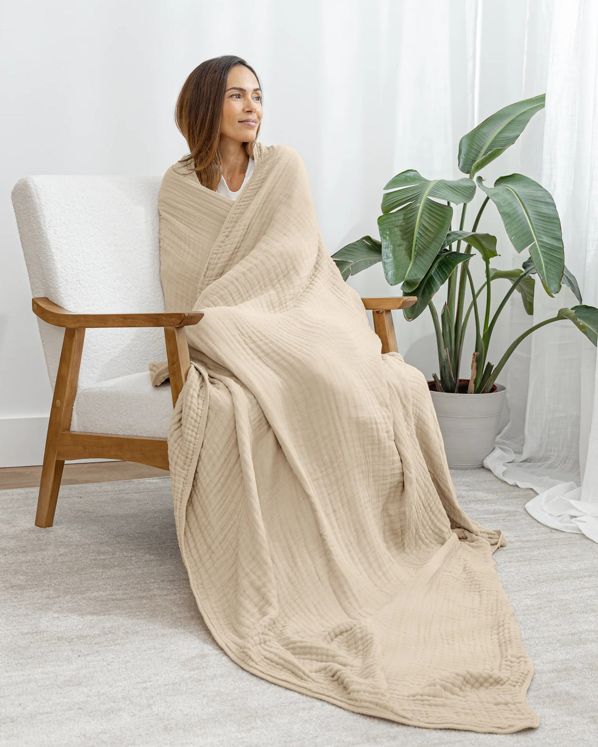 Femme enveloppée dans la couverture en mousseline sur un fauteuil