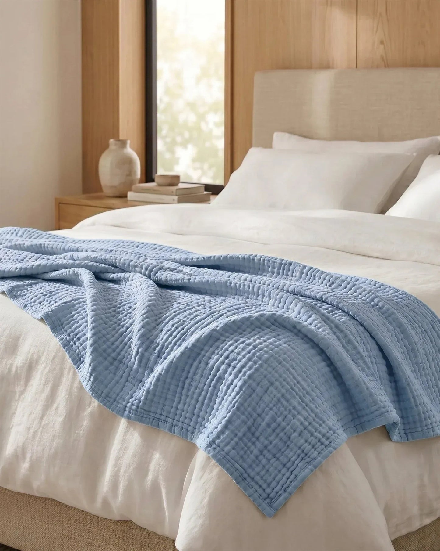 Couverture en mousseline coloris Ciel sur un lit