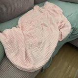 Couverture rose pastel drapée sur un canapé