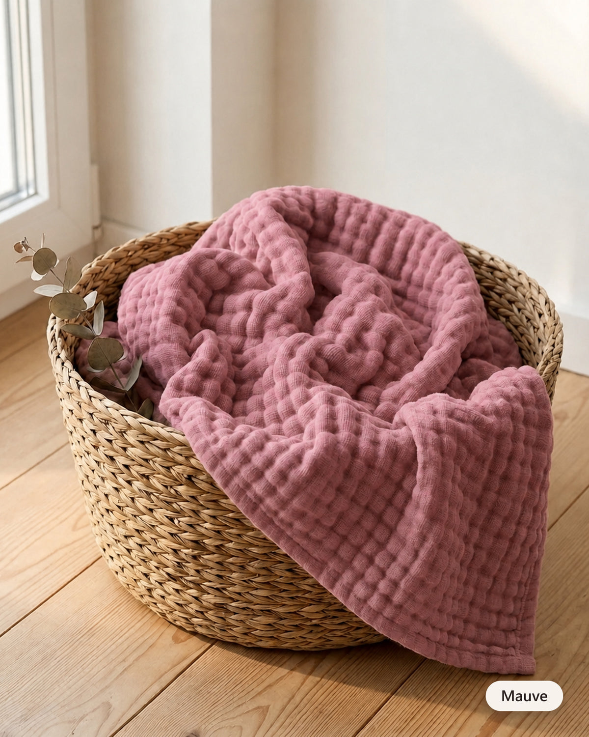 Couverture en mousseline coloris Mauve dans un panier en fibre naturelle